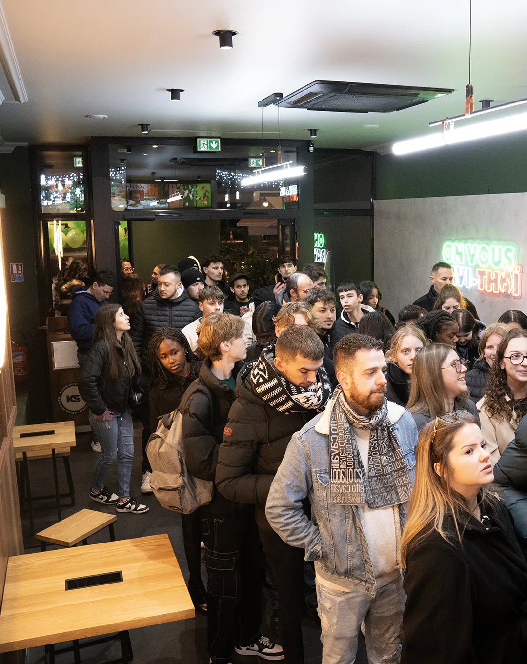 Foule de clients dans le restaurant Krousty Sabaïdi avec tables en bois et éclairage moderne.